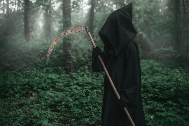 Death with a scythe in the dark misty forest