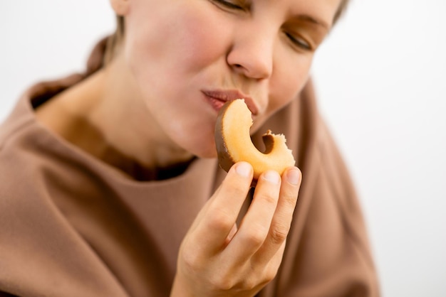 Foto delizia decadente una donna attraente nel suo massimo splendore assapora il piacere peccoso di una ciambella ricoperta di cioccolato