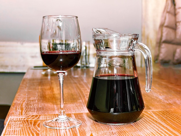 Foto decanter e un bicchiere di vino su un tavolo di legno