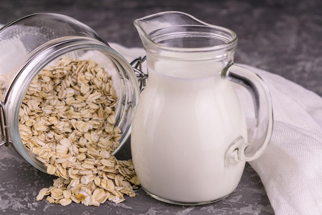 Decanter with oat milk on a gray background Organic vegetarian product