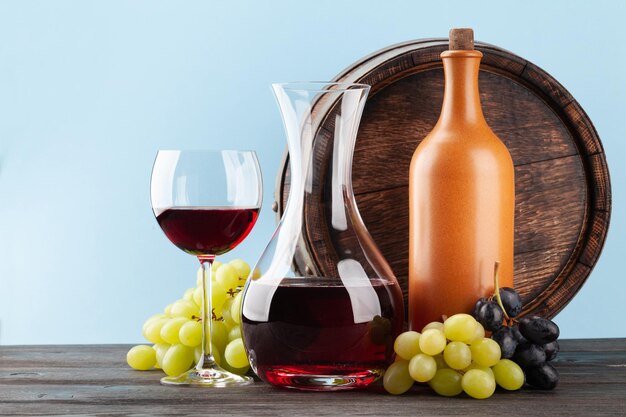 Decanter with red wine and old wooden barrel