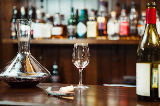 Photo decanter with wine and a glass on the bar counter