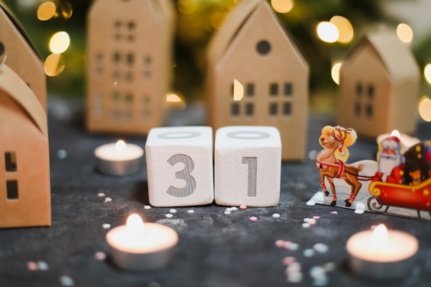 December 31 Wooden cubes calendar christmas decorations model paper houses and Christmas tree