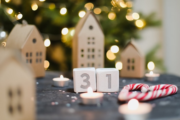 December 31 Wooden cubes calendar christmas decorations model paper houses and Christmas tree