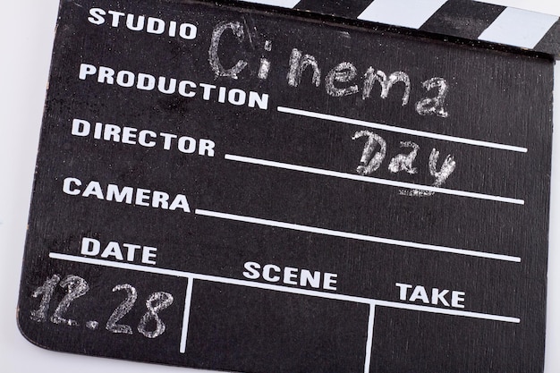 Photo december world cinema day closeup cinema clapperboard chalk handwriting of date