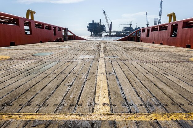 Photo deck of an anchor handling tug boat overlooking a oil production platform at offshore oil field