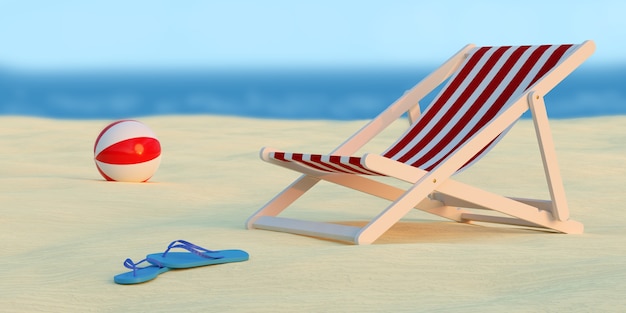 Deck chair, ball and pair of flip flops on the beach with the sea behind