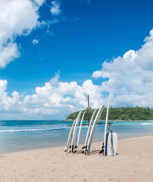 Deck chairs on beach against blue sky