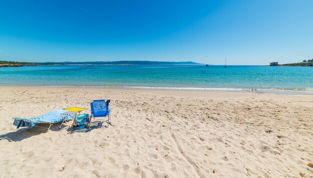 Deck chairs on beach against clear blue sky