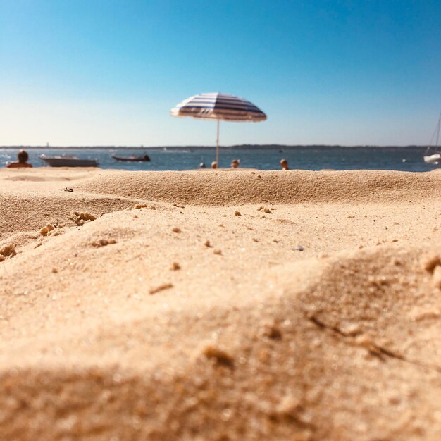 Deck chairs on beach against clear sky