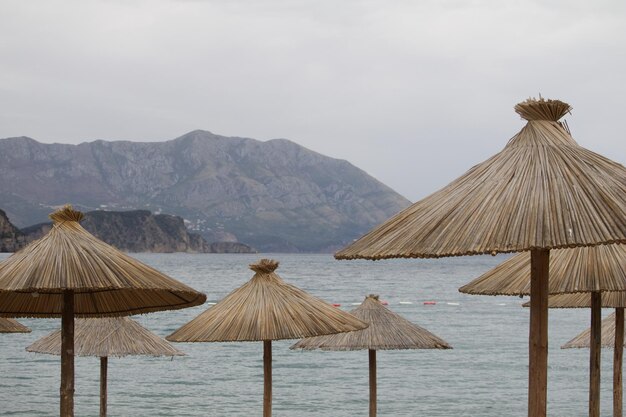 Deck chairs on beach against sky