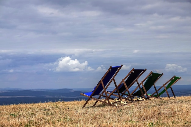 Photo deck chairs on field against sky