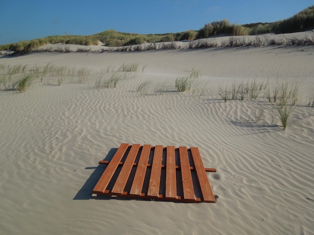 Лежачие стулья на песке на фоне неба