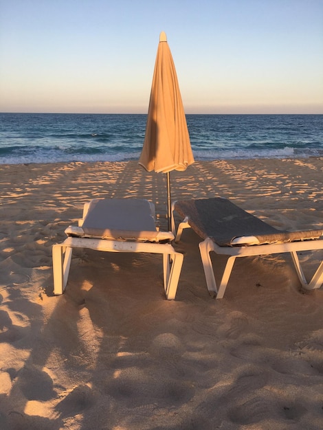 Foto deckstoelen op het strand tegen de lucht