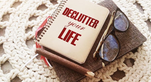 Photo declutter your life on the cover of notebook eye glasses and pen concept meaning free less chaos fresh clean routine career and private business concept