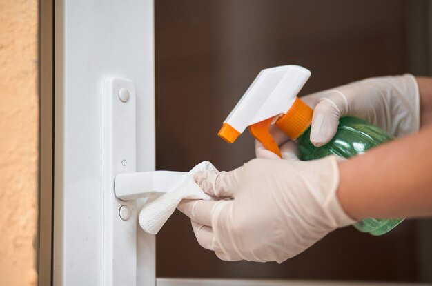 Decontaminating the surface of the door handle.