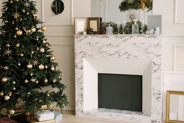 クリスマスと新年の装飾。クリスマスツリー、暖炉、お祝いテーブル付きのリビングルーム