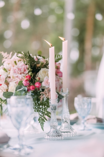 照片装饰桌子上的餐具和用火鲜花和蜡烛
