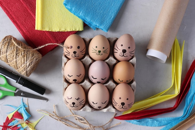 Decorare le uova di pasqua usando carta colorata e pergamena a forma di conigli usando un pennarello dra