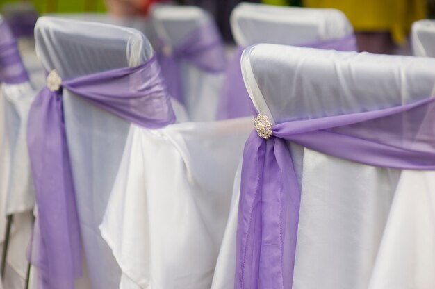 Decorated chairs on wedding ceremony in park