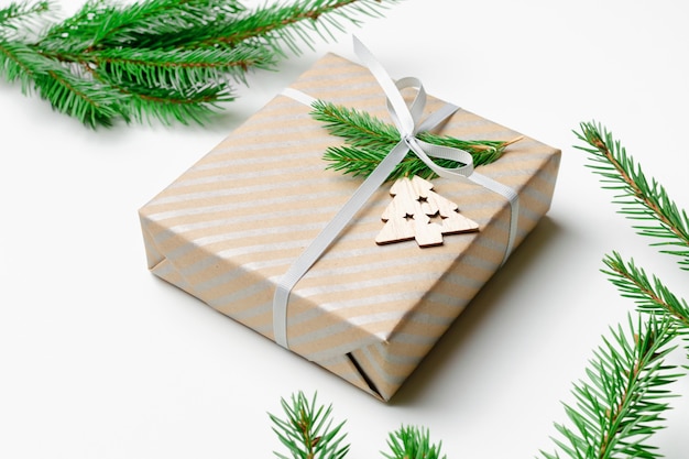 흰색 바탕에 전나무 나뭇가지가 있는 장식된 크리스마스 선물 상자