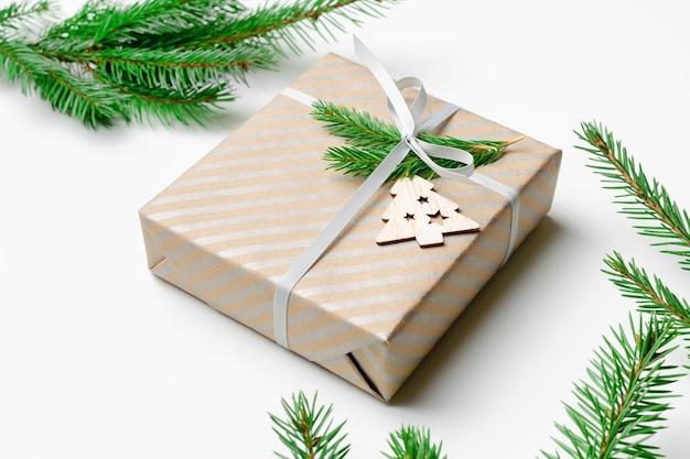 Decorated christmas gift box with fir tree branches on white