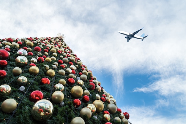 Decorated Christmas tree and airplane in  blue sky