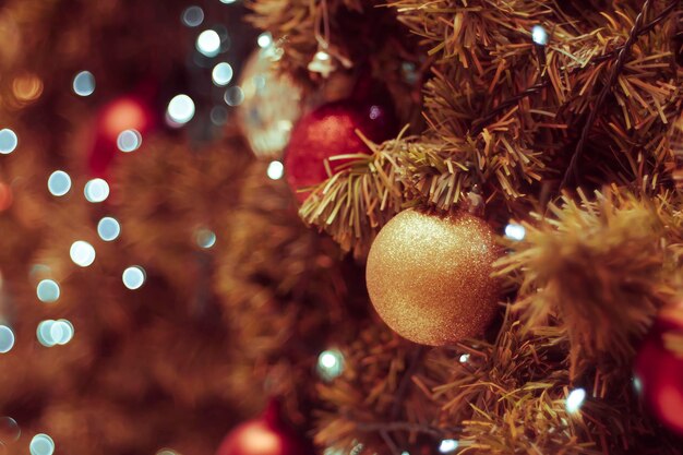 クリスマスツリーの飾り付け: 黒い背景に飾られたクリスマスツリー クリスマスの飾りつけ: 松の枝に赤いボールを吊るす クリスマスツリーズの花束と装飾品を抽象的なボケ背景にコピースペースで飾る