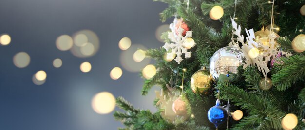 松の枝や装飾品にぶら下がっている飾られたクリスマスツリー