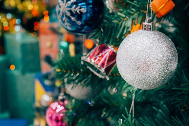 Decorated Christmas tree with colorful bauble on sparkling bokeh light blurred background