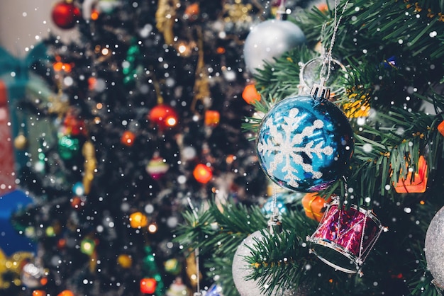 Украшенная рождественская елка с красочной безделушкой на сверкающем боке светлом размытом фоне