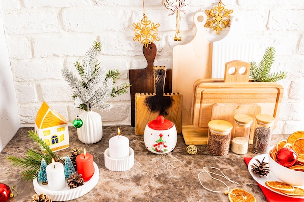 正月とクリスマスのためのモダンな料理のカウンター トップ様々 な道具とクリスマスの装飾の白いレンガの壁