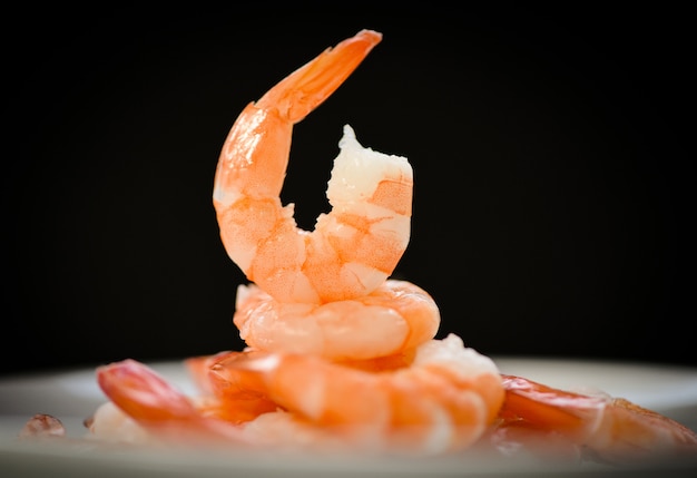 Decorated dining table with prawns boiled on dark