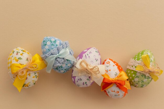 Decorated fabric Easter eggs with colored bows on a light background Easter background