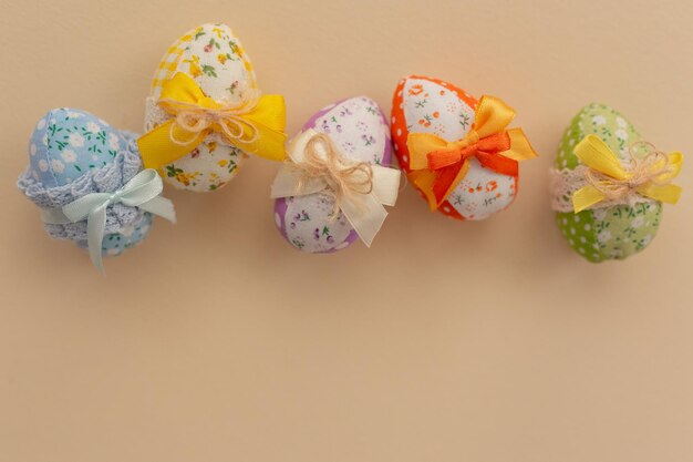 Decorated fabric Easter eggs with colored bows on a light background Easter background