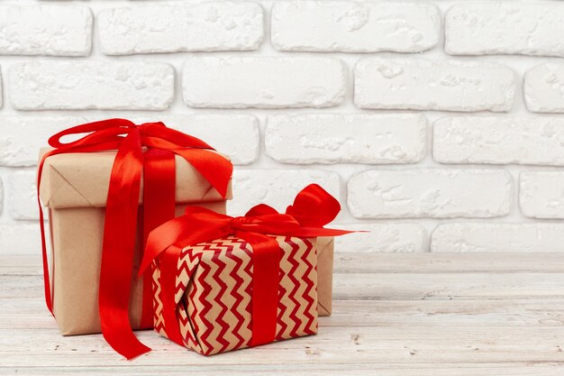 Decorated gift box put against white brick wall