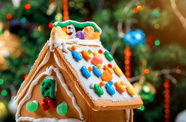 Decorated gingerbread house on christmas tree surface