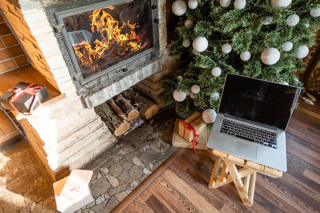 Decorated for new year room no people laptop with small gift boxes close-up in an old wooden house