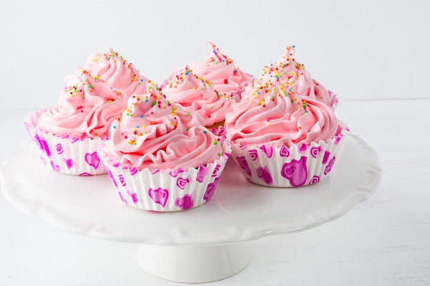 케이크 스탠드에 분홍색 생일 컵 케이크 장식