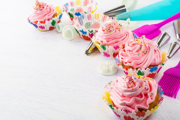 Decorated pink birthday cupcakes  and cookware