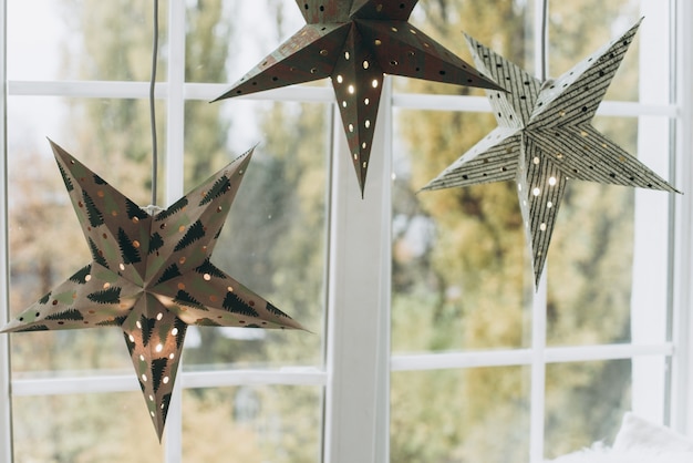 Decorated stars hang on the windowsill. Christmas and New Year concept