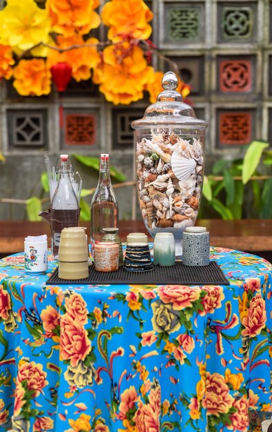 Decorated table with cup and bottle of water seashells religious buddhism ritual in Vietnam before