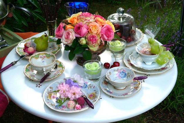 Decorated table with porcelain dishes and historic roses rosa