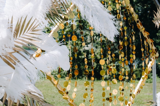 Photo decorated wedding arch in nature.wedding ceremony with an arch decorated with feathers in retro style