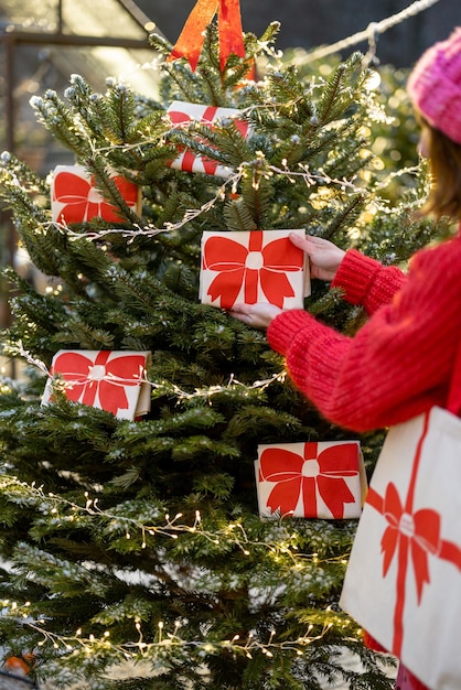 Decorates christmas tree with big red bows