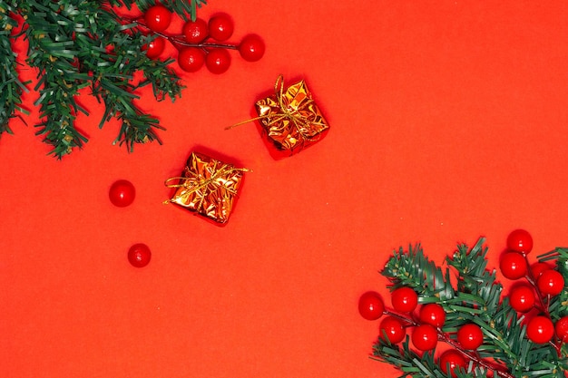 Decoratie kerstconcept Dennenboomtakken versieren met rode bessen en gouden geschenkdozen
