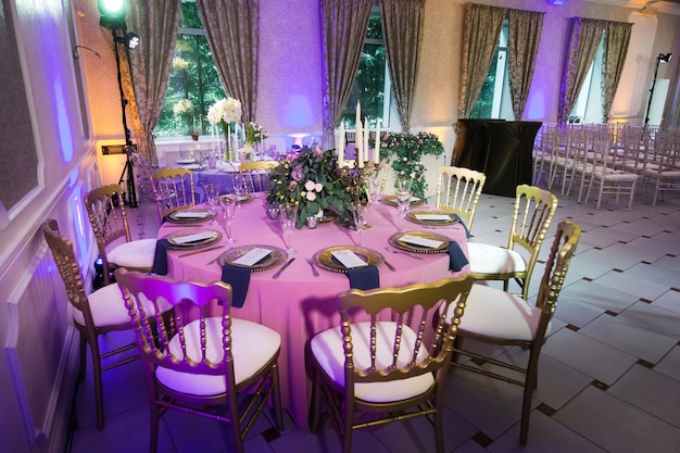 Decoratie van het feestelijke diner met roze bloemen op de bruiloftstafel in het interieur van het restaurant. Versierde tafel voor een feest.