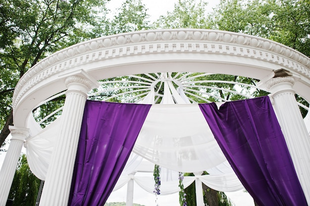 Foto decoratie van huwelijksboog met violet en witte doek