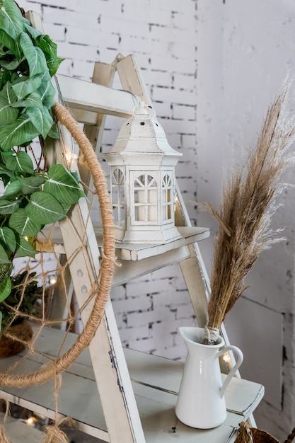 decoratie voor gezellig huis gemaakt met droge kruiden, lamp, kaarsen en slingers op betonnen muur. Gedroogde bloemen en vegetatie in een modern interieur. Interieur in eco-stijl