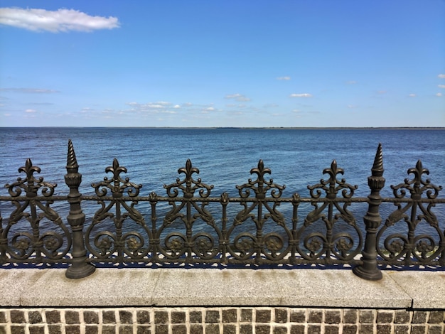 Decoratief gesmeed metalen hek aan de kust in de buurt van een betegelde stoep